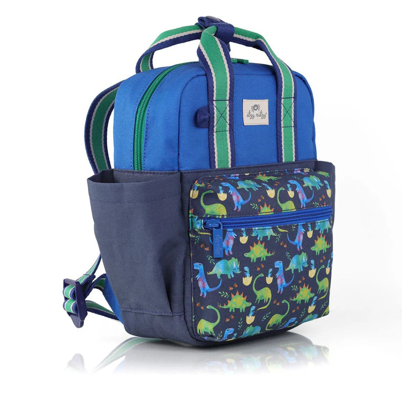 Itzy Ritzy Backpack blue with dinosaur-print front pocket; green striped handles show sturdy carry.