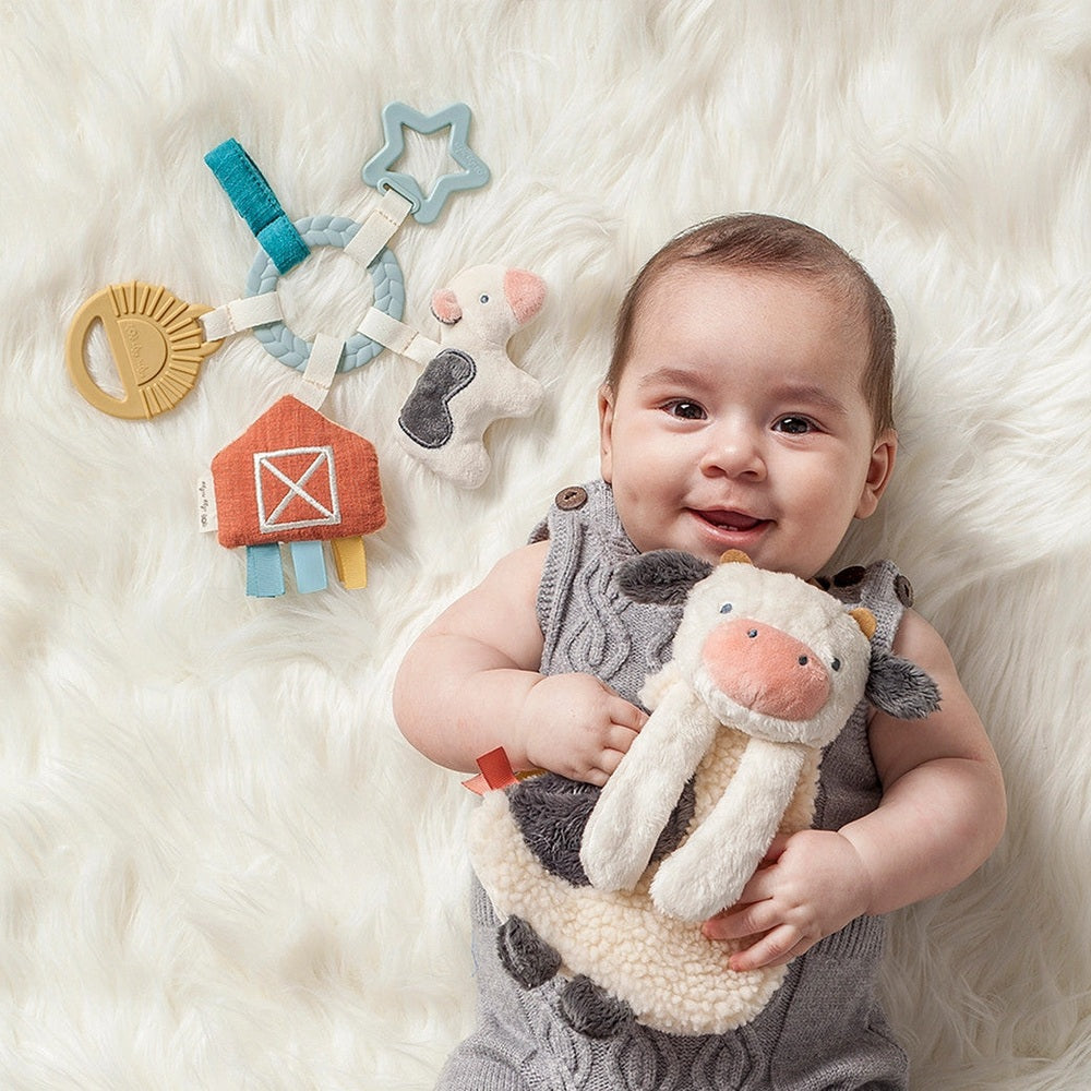 Itzy Ritzy Bitzy Busy Gift Set, 4-piece baby activity toys with plush cow, rattle ring and soft barn pieces