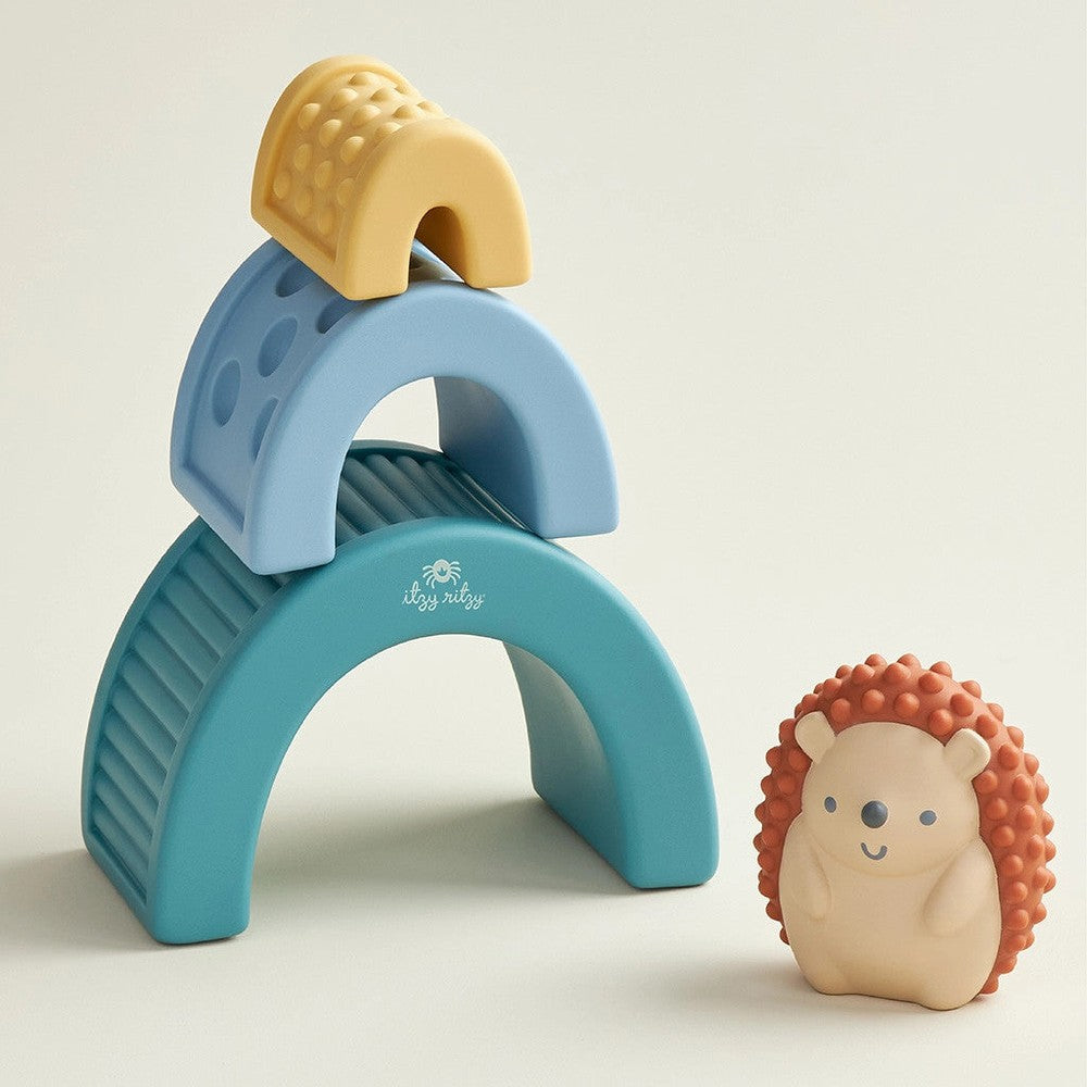 Itzy Ritzy Itzy Blocks sensory block set with three blue arches and a yellow cap, plus a hedgehog toy