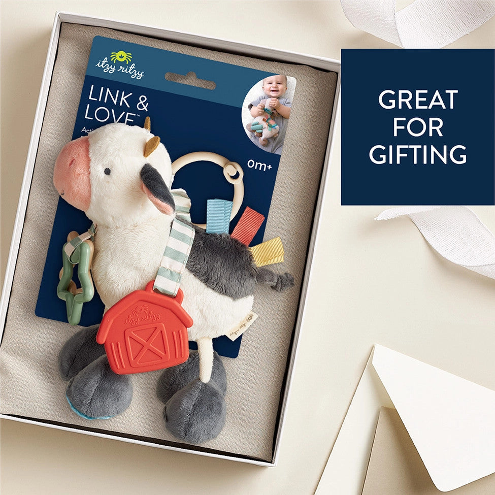 Itzy Ritzy Itzy Friends Link & Love Activity Plush cow toy with colorful ribbons