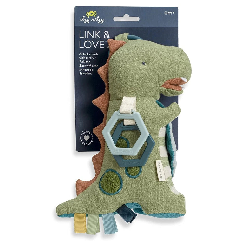 Itzy Ritzy Link & Love activity plush dinosaur in green linen with teal hexagon teether and ribbon tabs