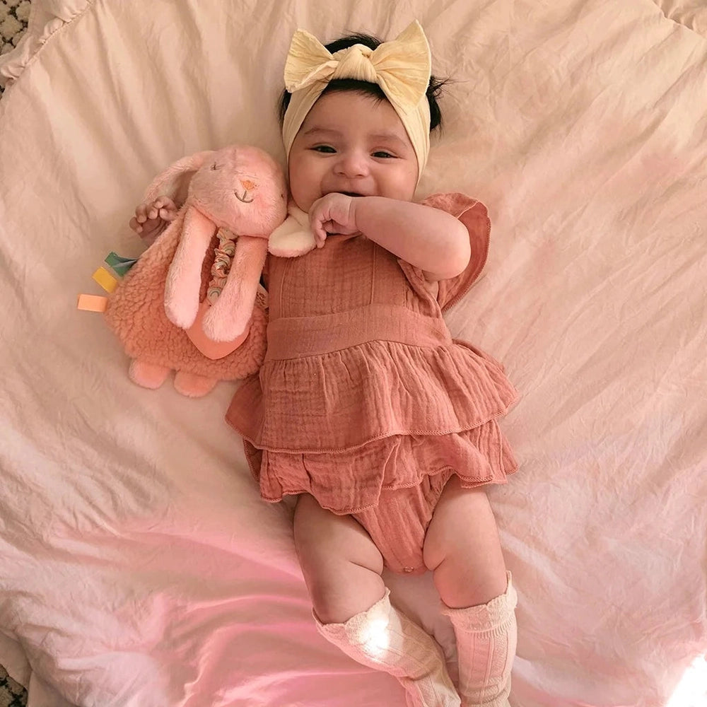 Itzy Ritzy Lovey plush teether toy in pink, baby holding a soft bunny companion