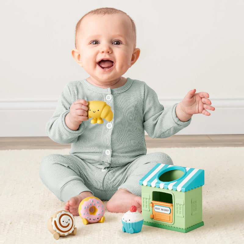Itzy Ritzy Itzy Play Bakery Spill and Fill activity toy set with pastel bakery shop and donut, cupcake, cookie figures