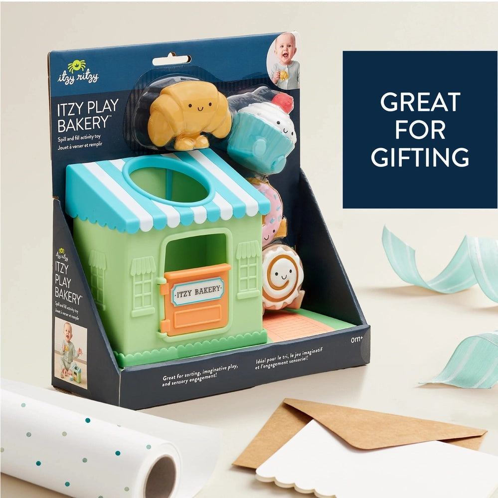 Itzy Ritzy Itzy Play Bakery activity toy with pastel green storefront, blue striped awning and pastries