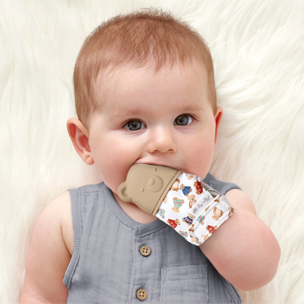 ITZY RITZY Itzy Ritzy Itzy Silicone Teething Mitts blue silicone teething mitt with whale motif worn over patterned fabric and textured for