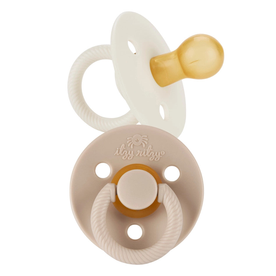 Itzy Ritzy Itzy Soother natural rubber pacifier in cream, 6-18M, with ring handle and shield visible.