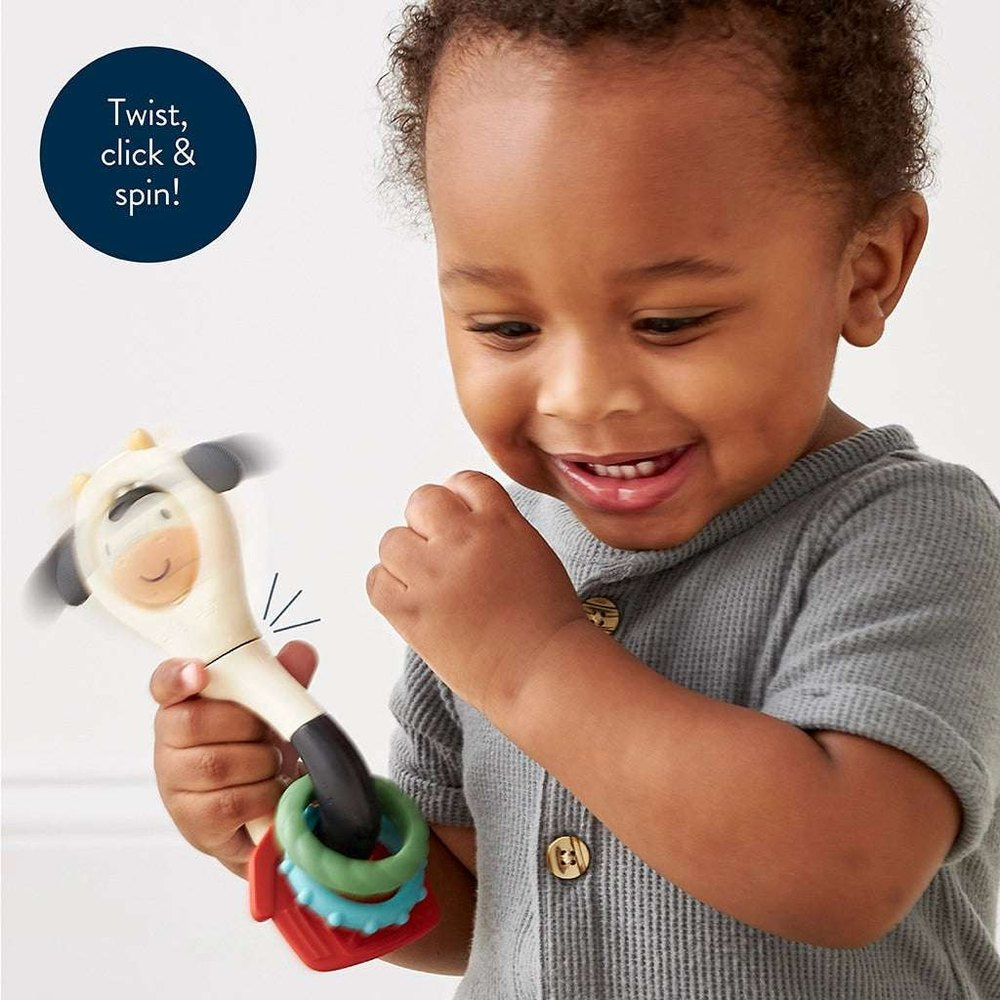 Itzy Ritzy Itzy Spinner teething toy with colorful ring stack held by toddler
