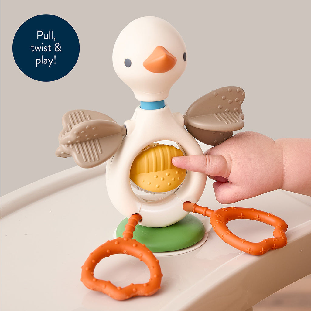 Baby pressing the Itzy Twist & Bop rolling belly on a high-chair tray