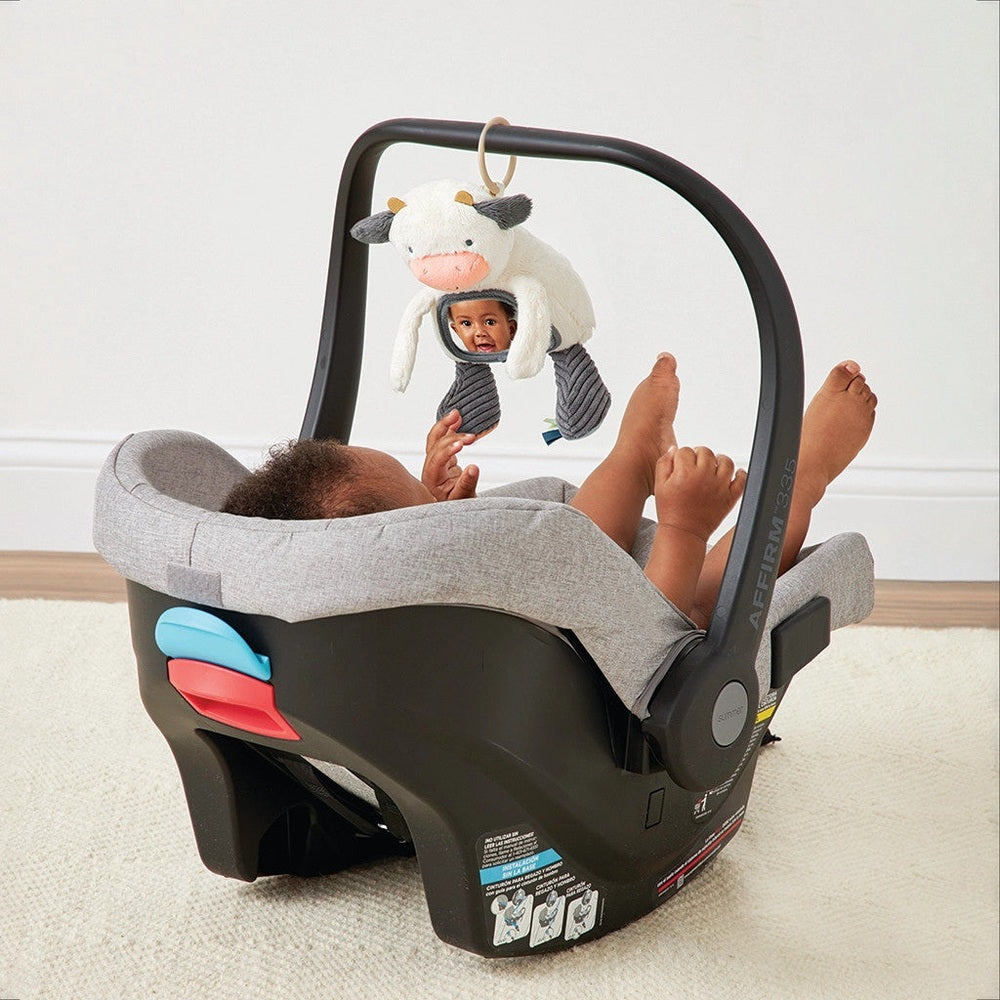 Itzy Ritzy Mirror enRoute baby car-seat toy with plush cow hanging from arch