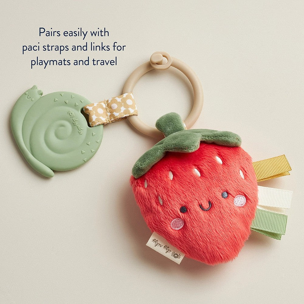 Itzy Ritzy Pal plush and teether strawberry toy with soft red fur, green leaf, and pastel ribbon rings