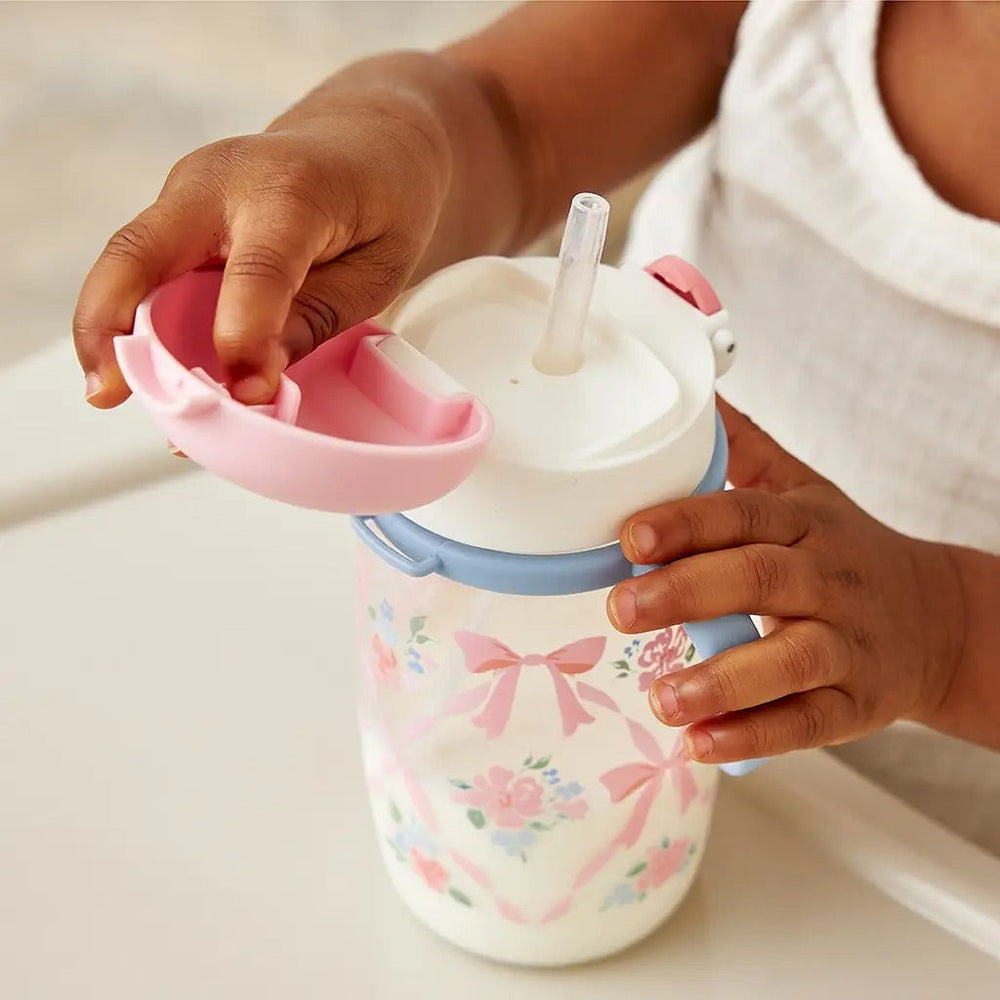 Itzy Ritzy Straw Cup with Snap-Close Lid in white floral print with pink bows and pink lid