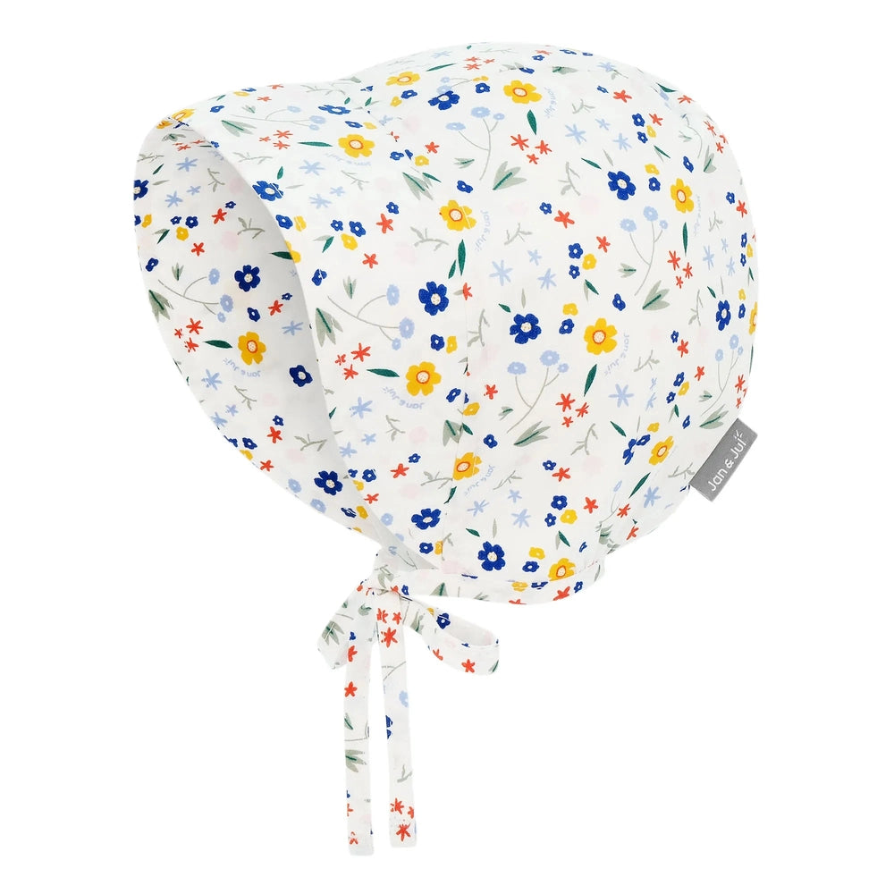 JAN & JUL Jan & Jul Baby Bonnet - Meadow Flowers Chin tie strings and side tag with scattered floral print img 1/5