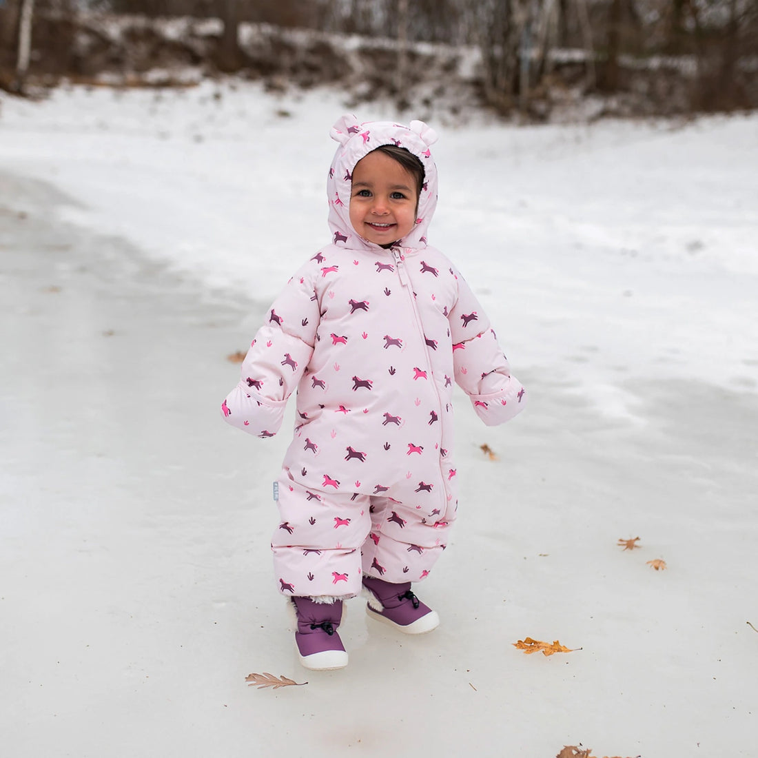 Jan & Jul Baby Insulated Snowsuit Pink Ponies — child wearing the insulated snowsuit in snow