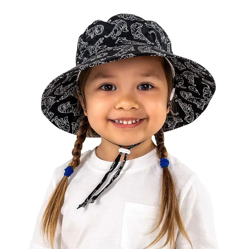 Jan & Jul Kids Cotton Bucket Hat Tiger worn by a smiling toddler; black tiger-print hat with adjustable chin strap.