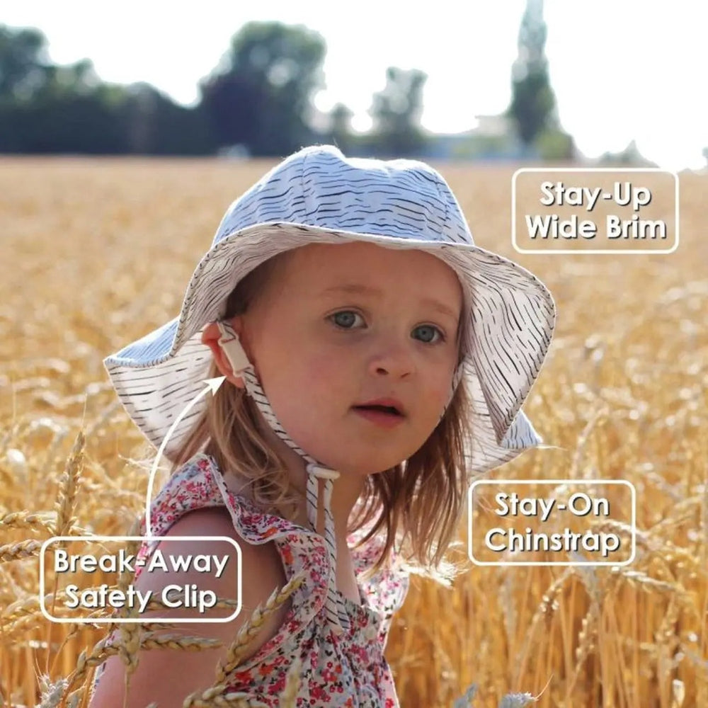 JAN & JUL Kids Cotton Floppy Hat Yellow Pineapple; stay-up wide brim and chinstrap with safety clip on a sunlit field.