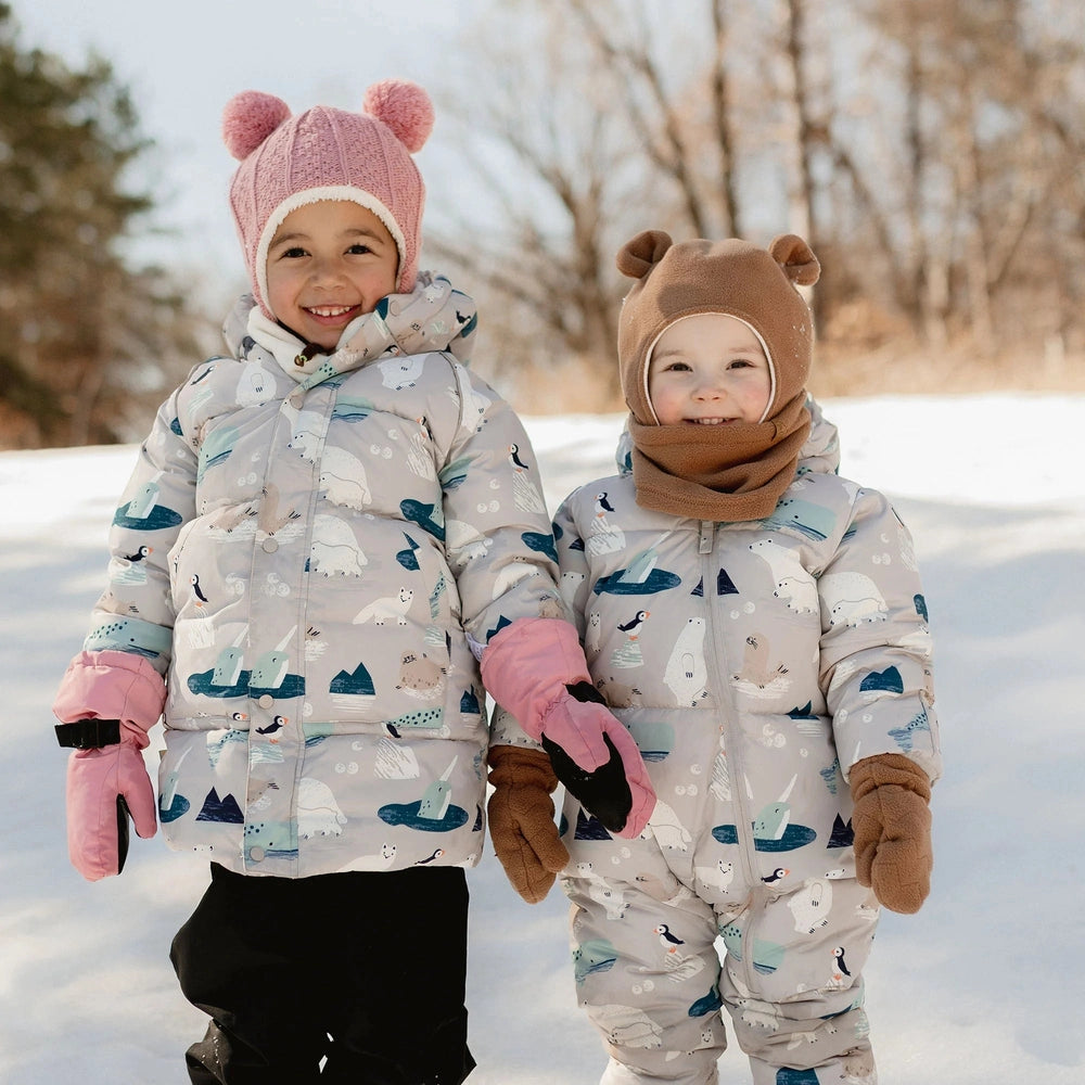 JAN & JUL Kids Fleece Neck Warmer on the right child in brown, keeping their necks warm in snowy outdoor play.