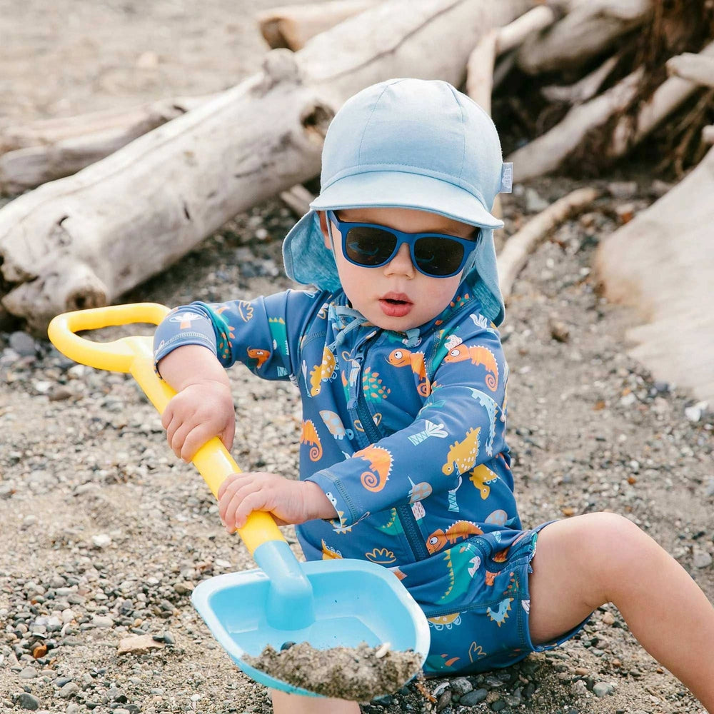 Jan & Jul Sun Soft Baby Cap Stormy Blue with neck flap, toddler in blue hat on the beach