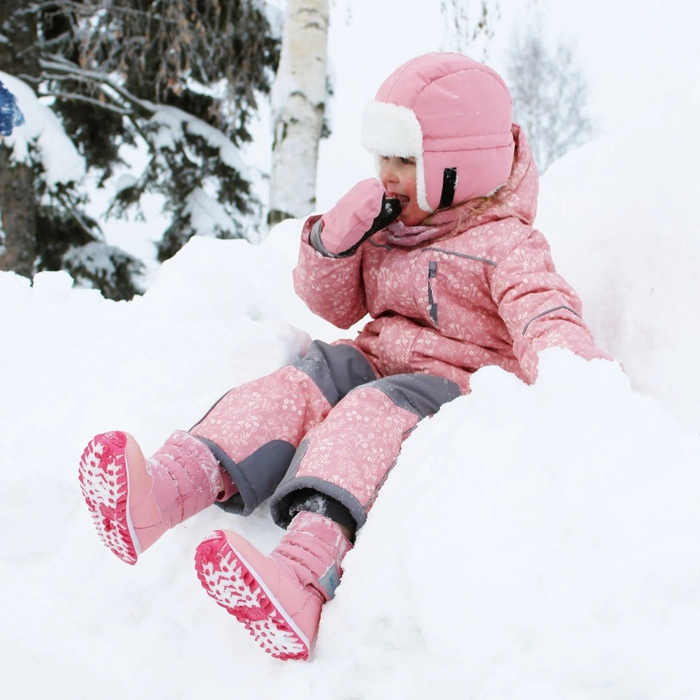 Jan & Jul Kids Tall Puffy Winter Boots dusty pink; toddler sliding in fresh snow, showing warm, grippy pink soles.