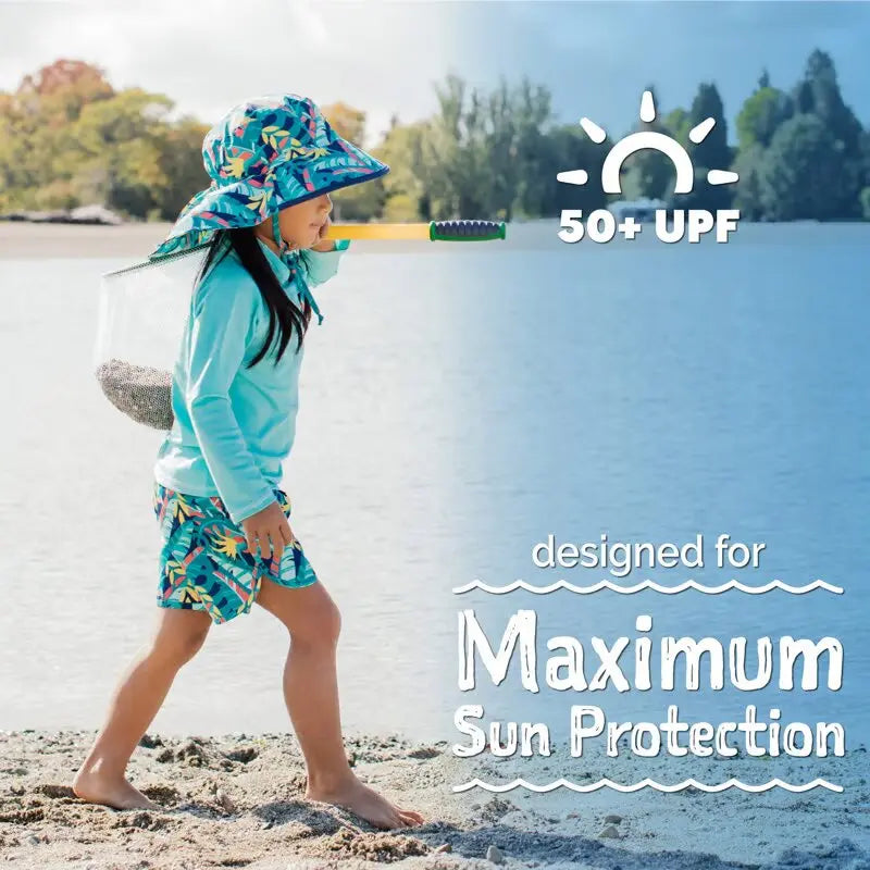 Jan & Jul Kids UV Rashguard Top Lagoon, turquoise swim shirt with 50+ UPF; child walks along the beach in matching shorts.