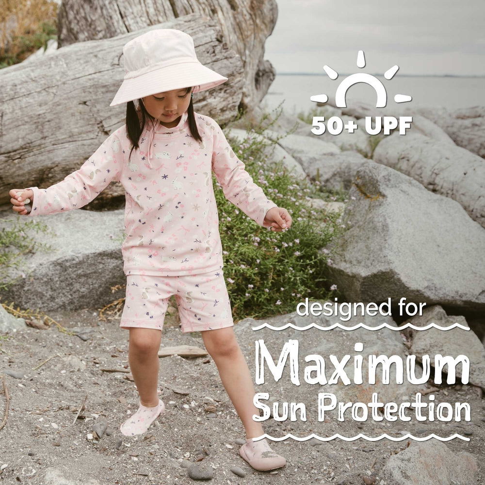 Toddler girl in pink UPF 50+ swim outfit and sun hat