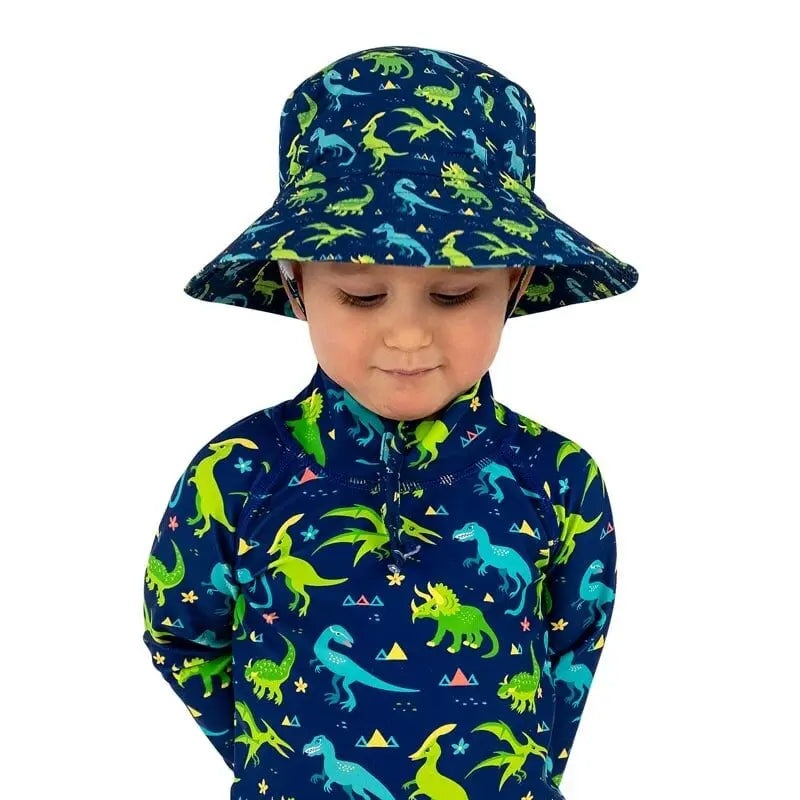 JAN & JUL Dinoland water-repellent bucket hat on a toddler, navy with neon dinosaurs.