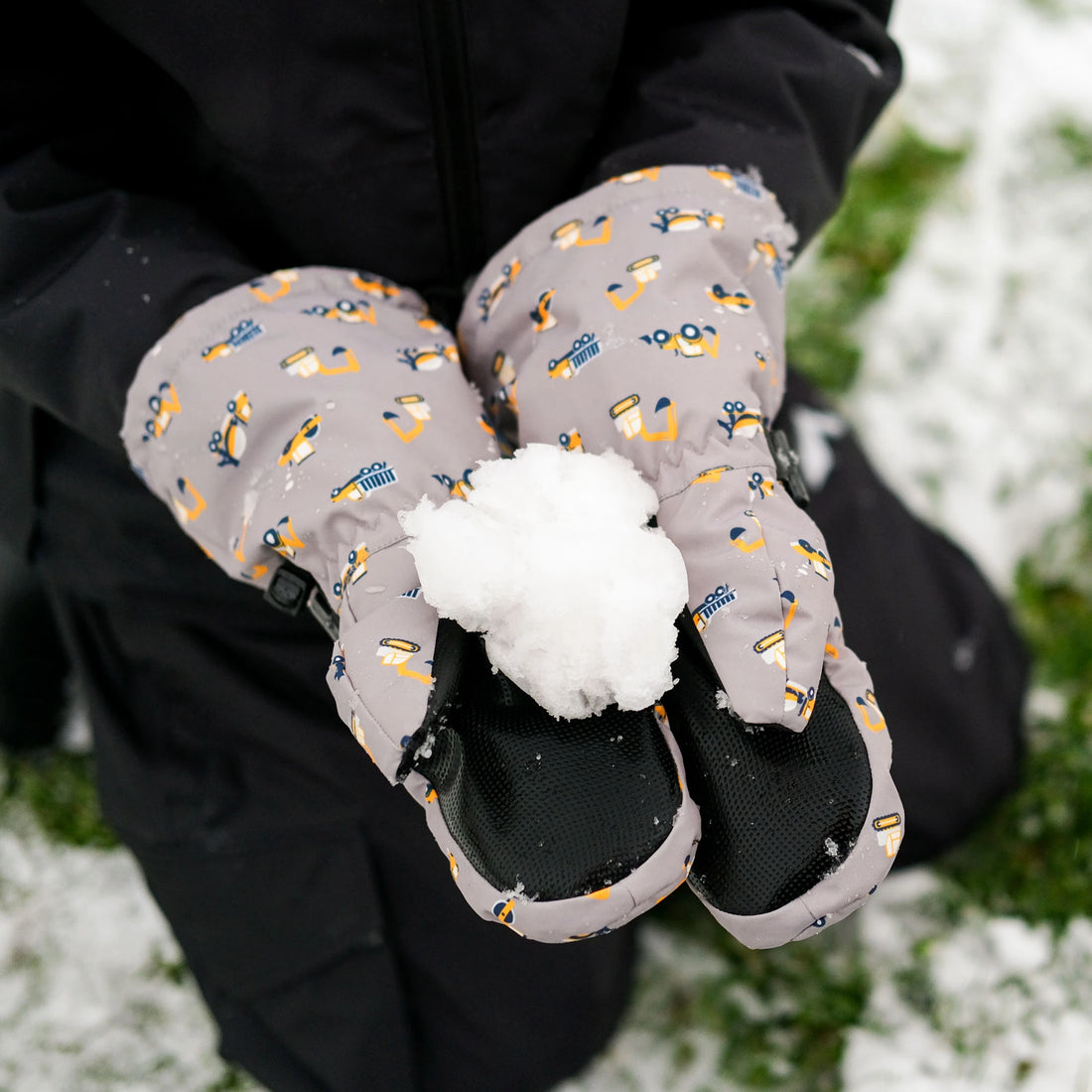 Close-up of Jan & Jul Grey Construction Mittens holding a snowball.