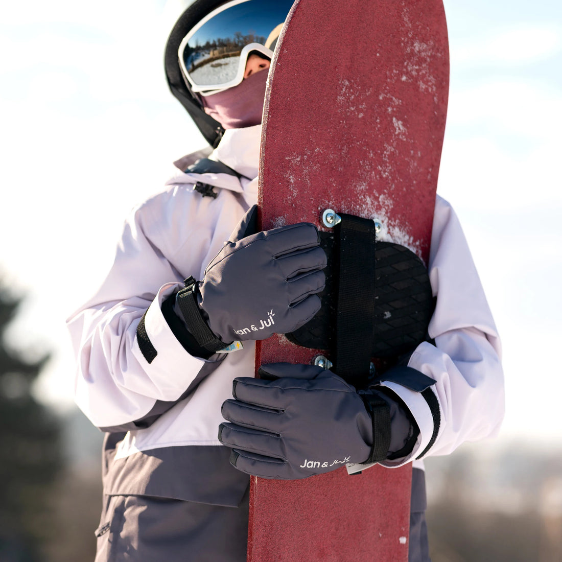 Close-up of Jan & Jul Dark Slate Snow Gloves holding a snowboard.