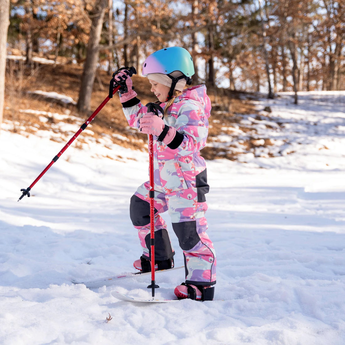 Side view of a child skiing in a Jan & Jul Snow Fox snowsuit.