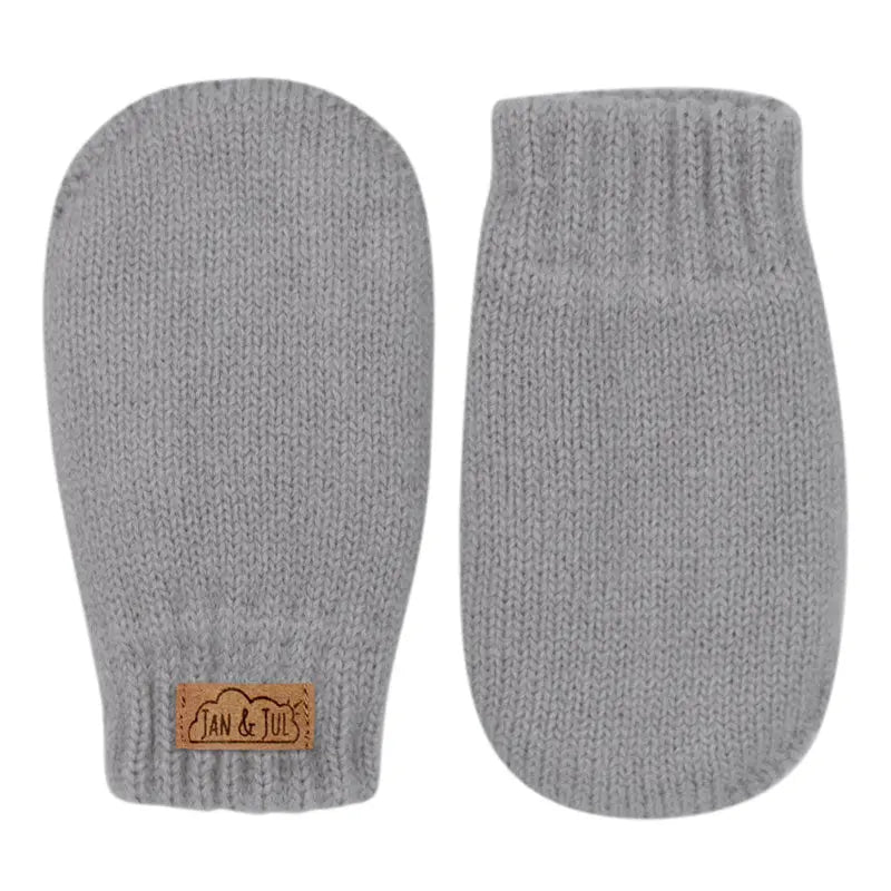Jan & Jul Knit Mitten Grey; two soft ribbed baby mittens with a brown logo patch laid flat.