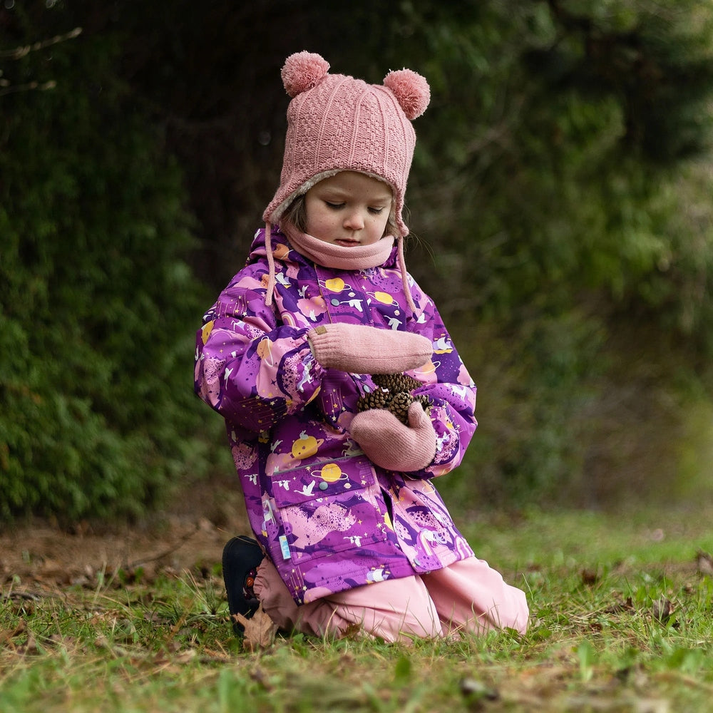 Jan & Jul Waterproof Cozy Dry Rain Jacket Purple Dream; child outdoors in pink knit hat and gloves, collecting pinecones.