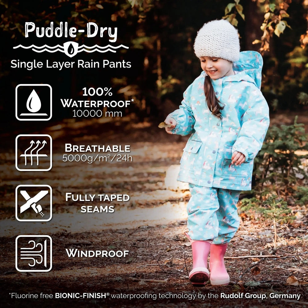 JAN & JUL Waterproof Puddle Dry rain pants black on a child walking through leaves; fully taped seams, breathable, 100% waterproof.