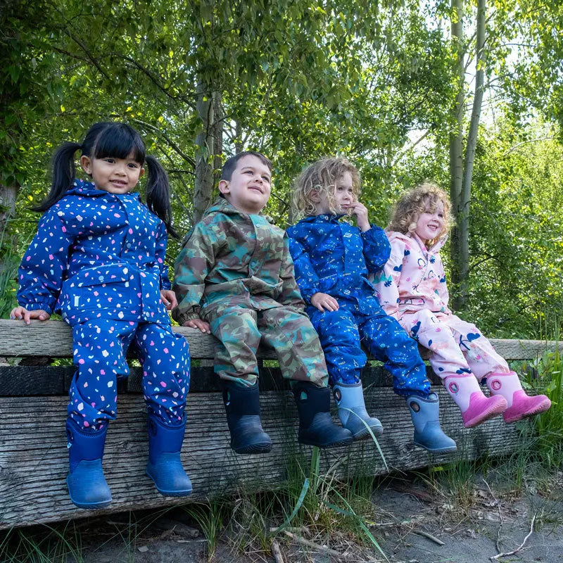 Jan & Jul Waterproof Puddle-Dry Rain Pants Woodland Camo; four kids sit on a wooden fence in matching waterproof outfits.