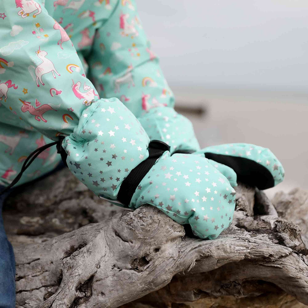 Jan & Jul Waterproof Toasty Dry Snow Gloves Mint Star; toddler mittens with silver stars worn as they grasp weathered driftwood.