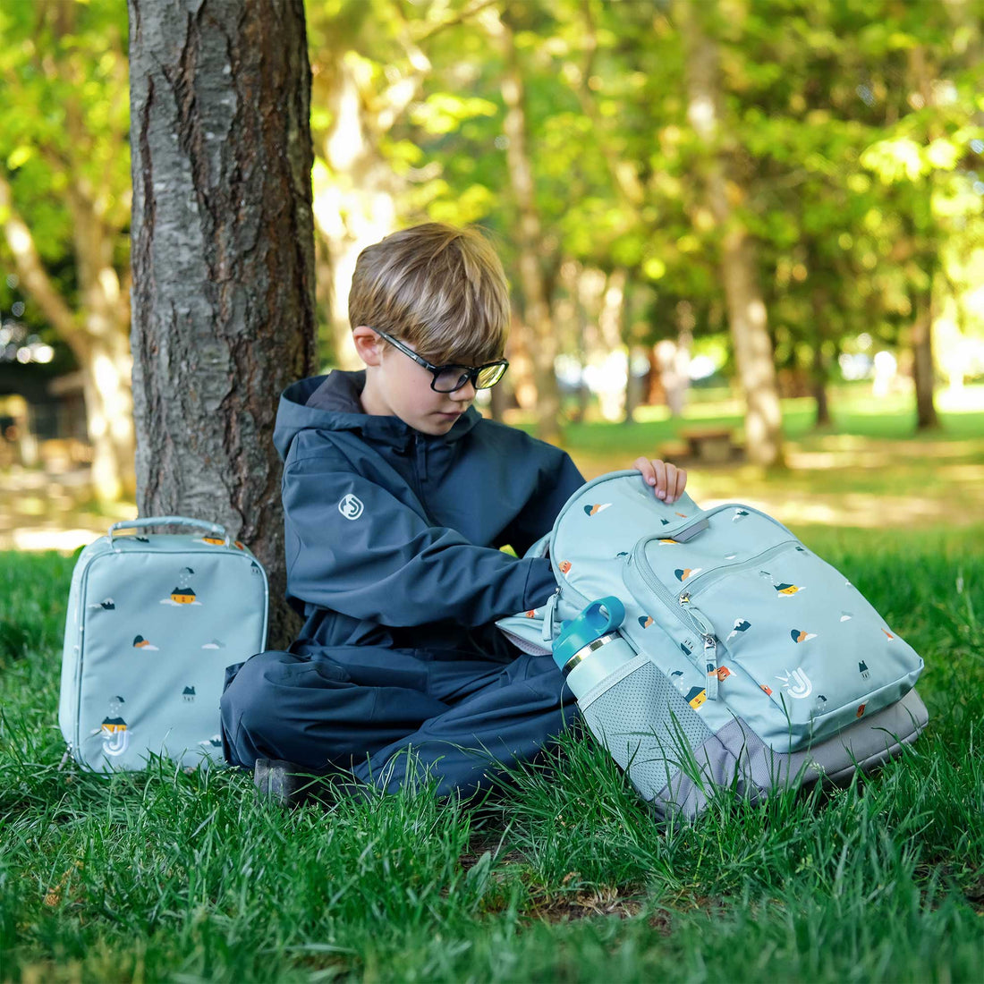 Child using matching Home Sweet Home backpack and lunch bag outdoors