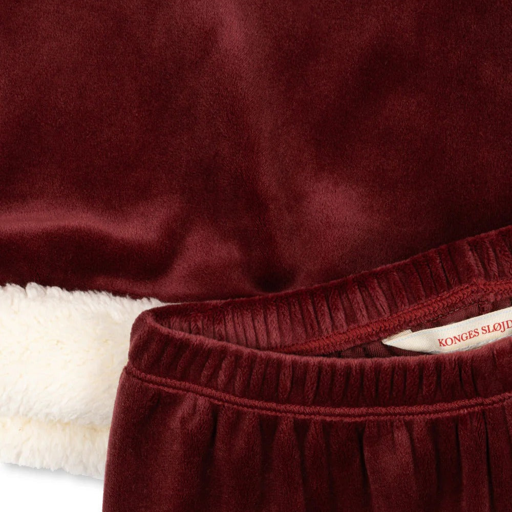 Konges Slojd Christmas Set Red Dahlia baby outfit in burgundy velvet with white faux-fur lining, tag visible.