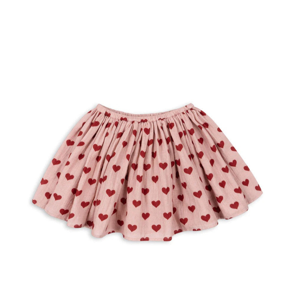 Konges Slojd Coco Skirt Gots Amour Mellow in pink with red hearts, laid flat to show elastic waist and flared twirl.