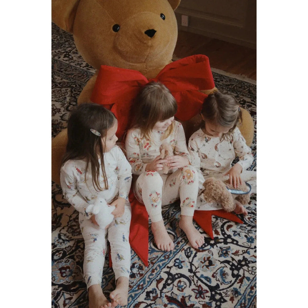 Konges Sljd Holiday Basic Blouse/Pants Set GOTS Luna, three kids in cream floral pajamas sit on rug with a large teddy bear