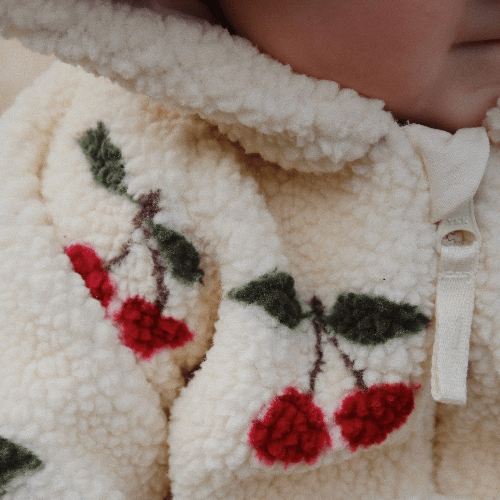 Konges Slojd Jody teddy onesie in cream fleece with red cherry embroidery.
