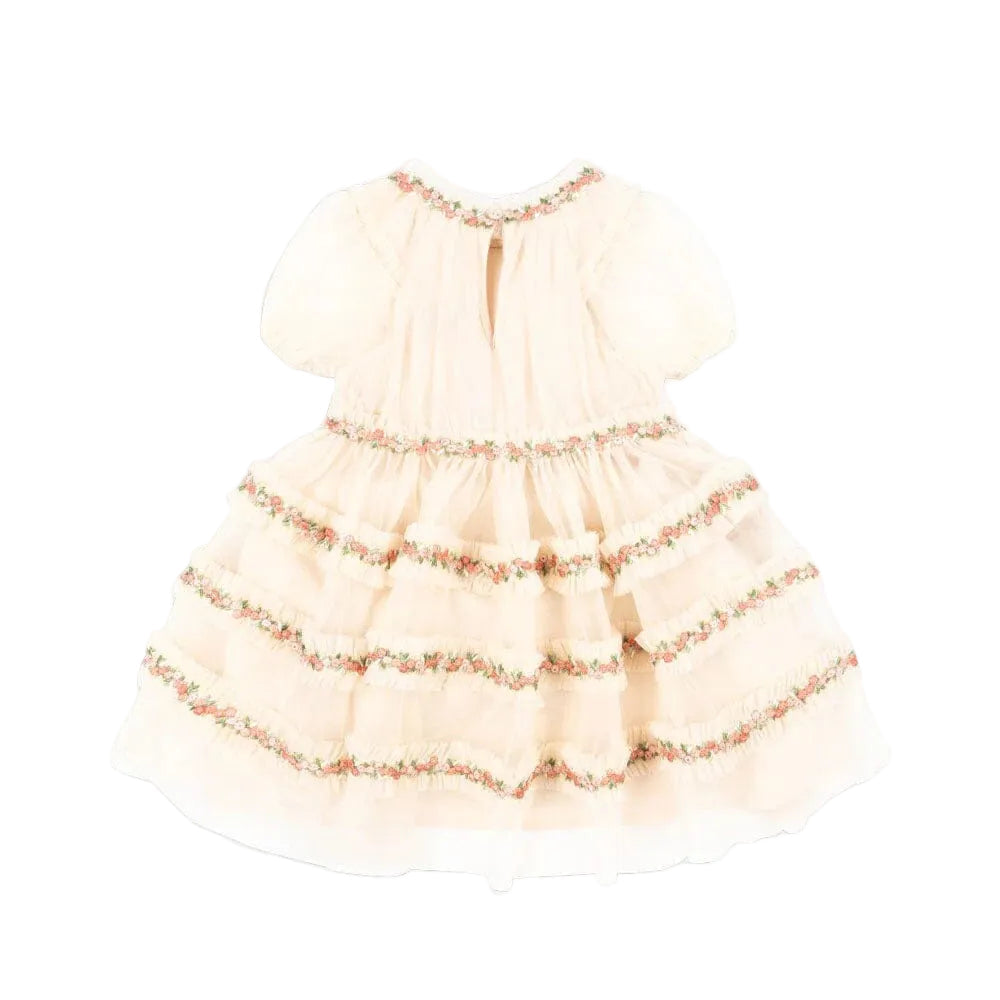 Konges Slojd Joelle Dress in Buttercream with pink floral trim, puff sleeves, and tiered ruffle skirt.
