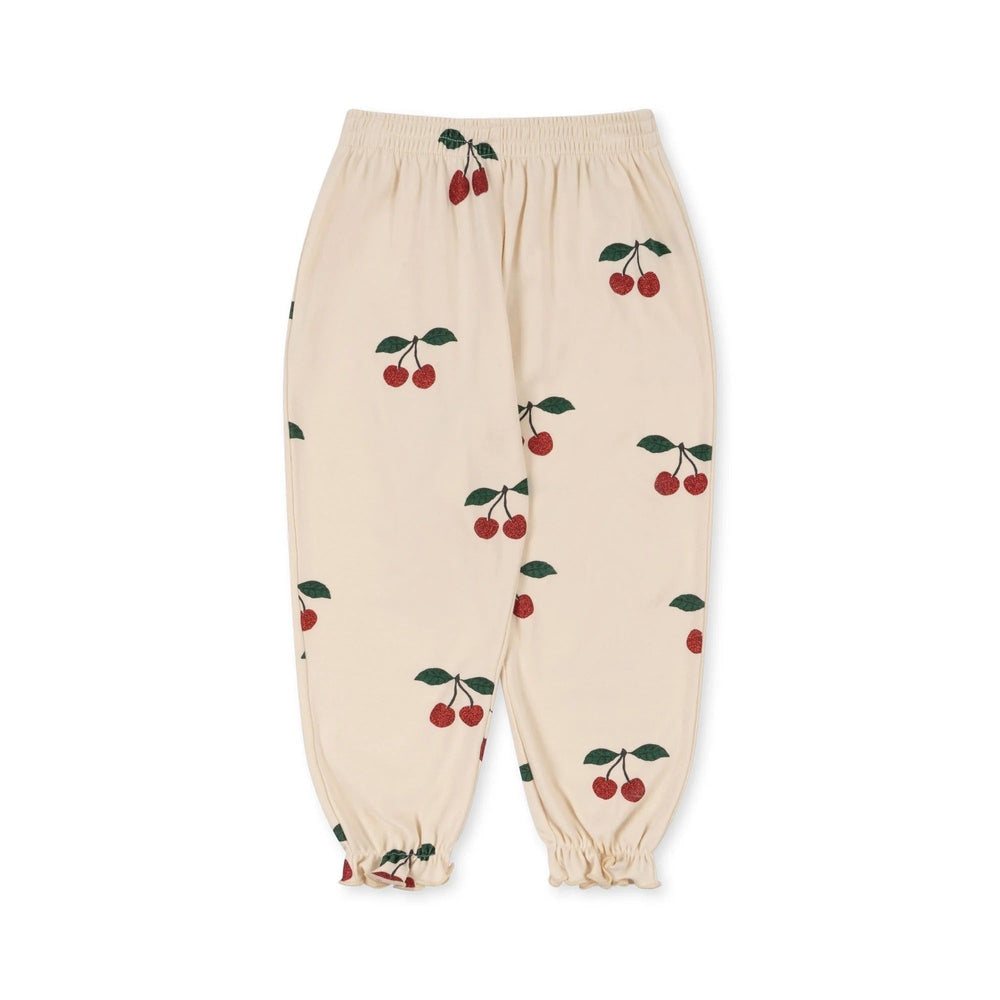 Konges Slojd Malli Glitter Pants in cream with cherry print; elastic waist and ruffle cuffs shown laid flat.