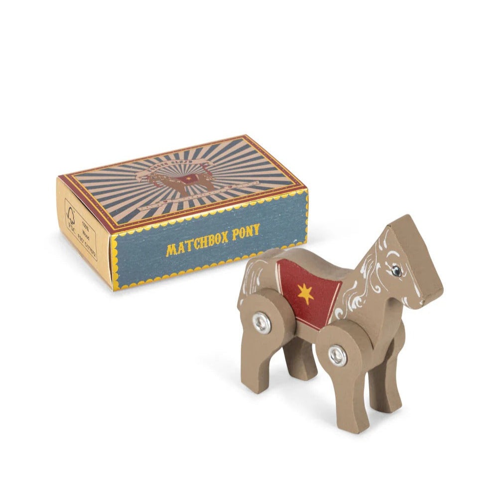 Konges Sljd Matchbox Animals wooden pony with decorative saddle and visible joints beside the striped box.
