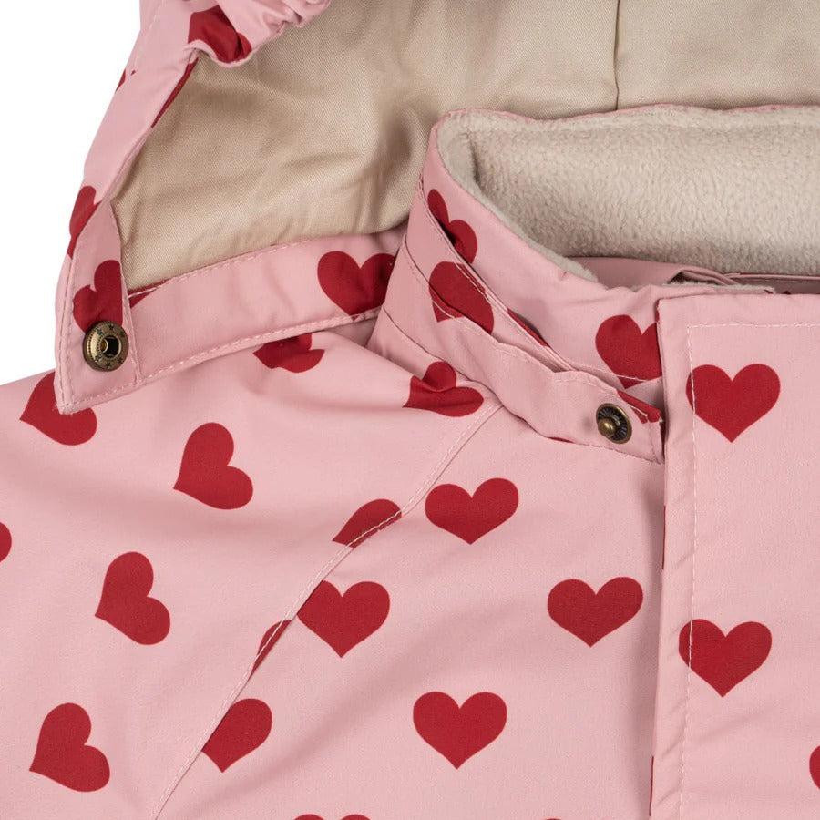 Konges Slojd Mismou Jacket Amour Pink, pink heart-printed coat with fleece-lined hood and front snap buttons.