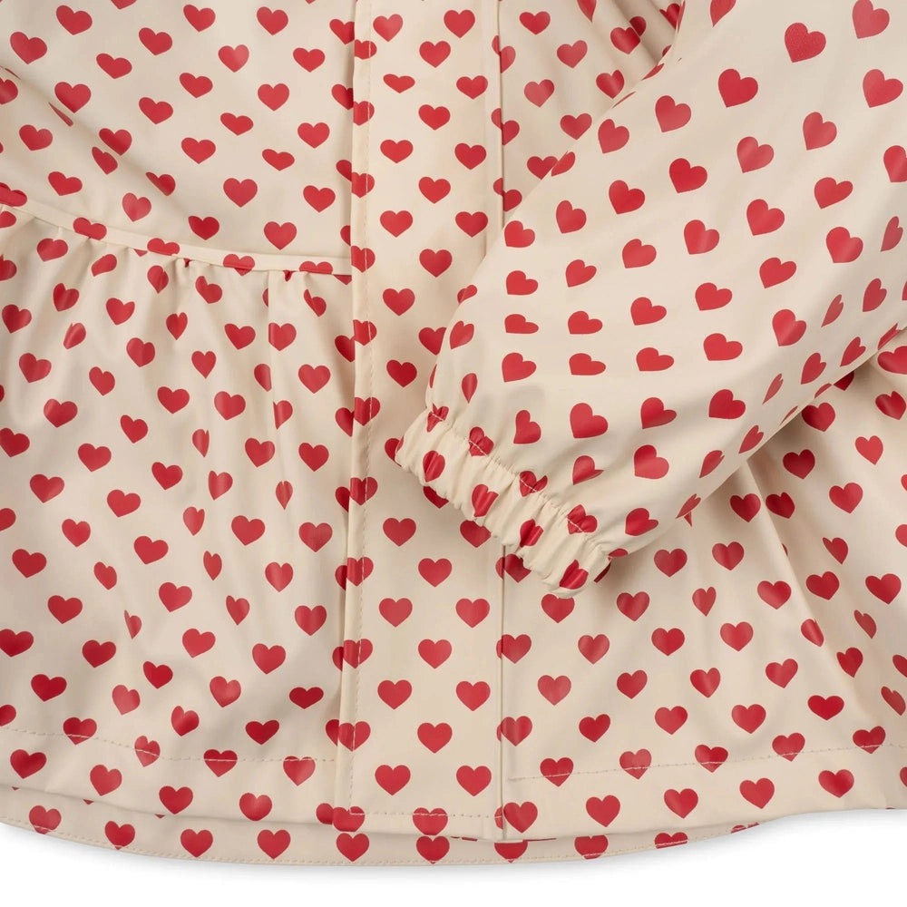Konges Slojd Rainy Palme Set Coeur Rouge baby jacket in cream with red hearts, front zipper and elastic cuffs shown.