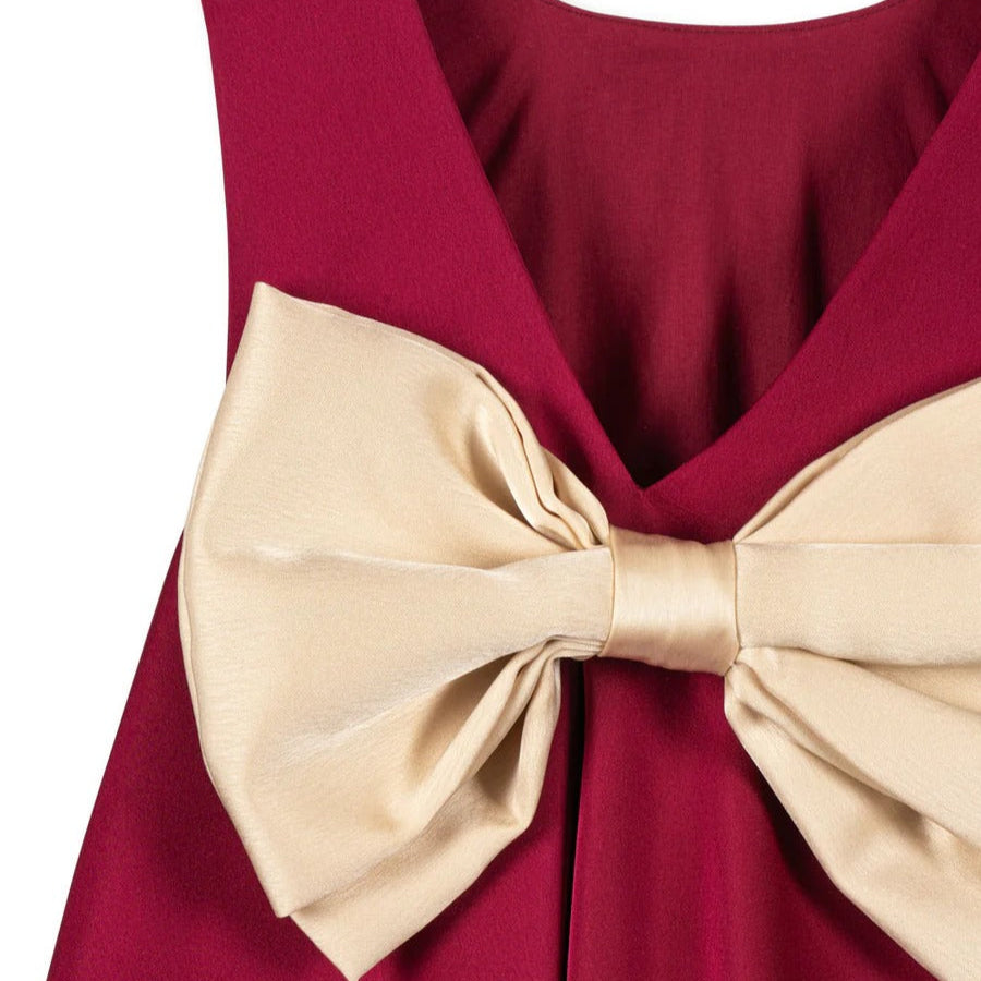 Konges Sljd Sheena Dress Sangria; burgundy baby dress with oversized beige satin bow belt tied at waist.