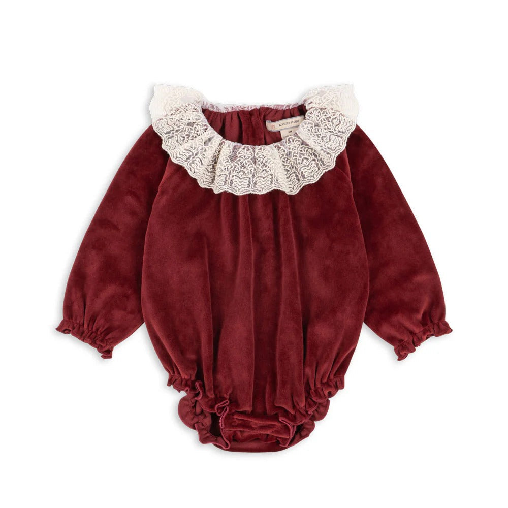 Konges Slojd Venola Romper Red Dahlia: velvet baby onesie with ivory lace collar and gathered cuffs.