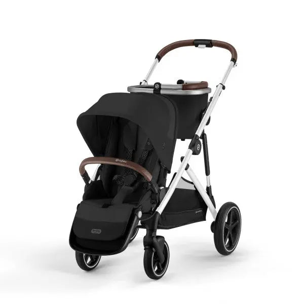 Lifestyle image of the Cybex Gazelle S V2 Stroller in black with brown accents; canopy open over a roomy seat and large storage basket.