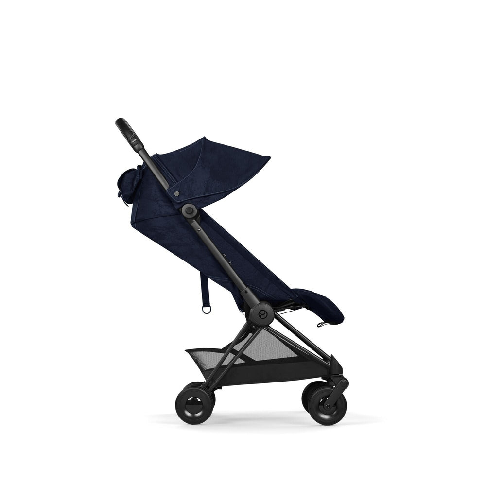 Lifestyle image of the Cybex Platinum Coya Compact Lightweight Stroller - Rebellious Luxury Denim Blue denim-blue cybex coya compact lightweight stroller with navy canopy and black frame.