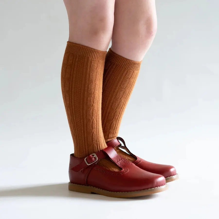 Little Stocking Co. Knee High Socks Almond on a child's legs, paired with red Mary Jane shoes.