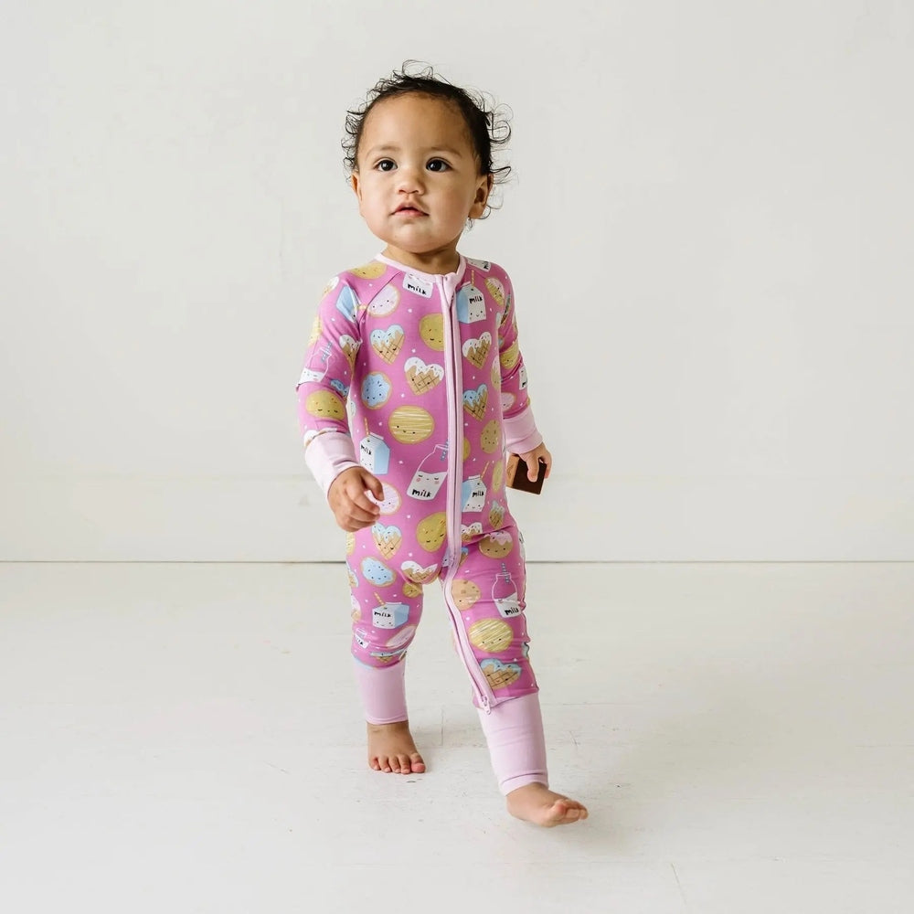 Littlesleepies Pink Cookies & Milk Bamboo Viscose Zippy; toddler in pink zip romper walking barefoot with a block.