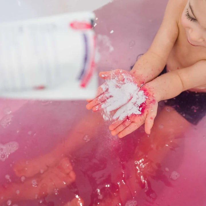 Loot Toy Co Foaming Bath Powder Raspberry in pink bath; baby hands cupping white foam